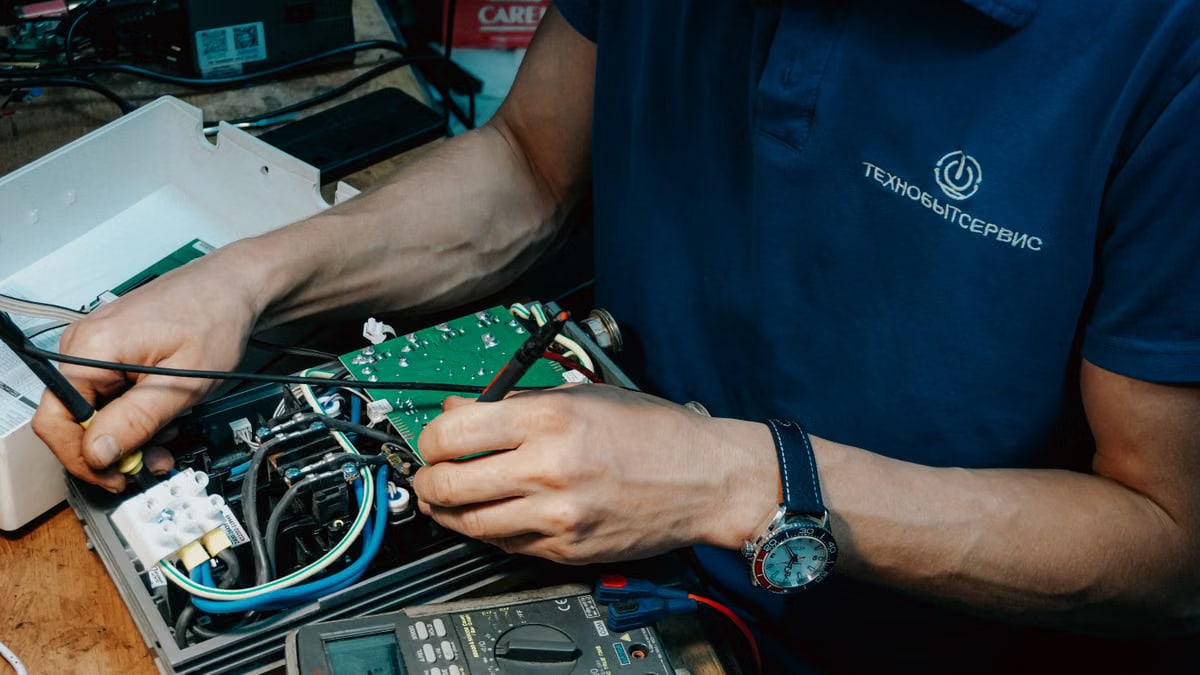 A technician methodically repairs a circuit board, showcasing expertise in electronics and technical skills.